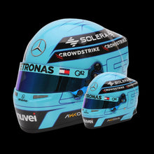 Load image into Gallery viewer, A mini replica helmet of George Russell, Mercedes F1 driver, in a 1:2 scale, featuring a light blue color with black and white accents, along with sponsor logos such as 'Astronas' and 'Crowdstrike'.